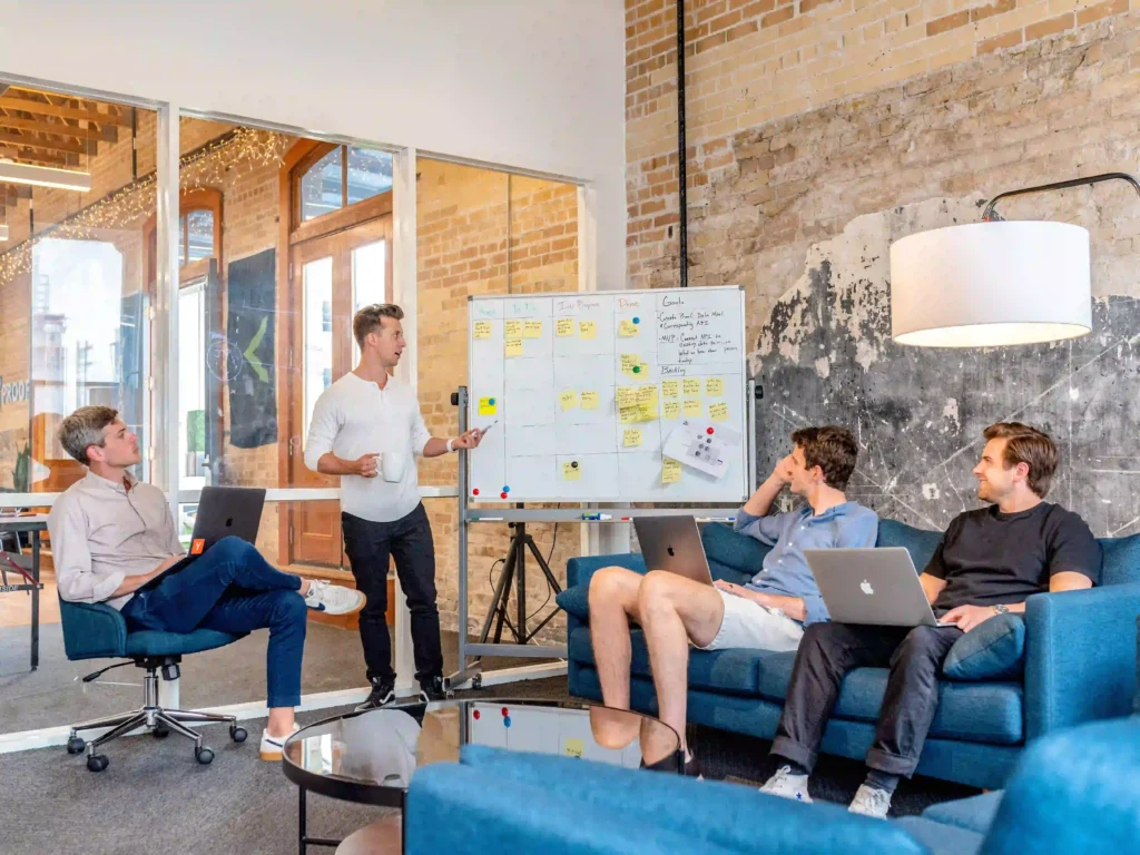 Group of people discussing in front of a kanban board